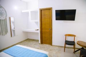 a bedroom with a bed and a table and a television at Hotel Palmas del Río Mompox in Mompos +33 photos