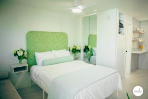 a bedroom with a white bed and a green headboard at Gulfside Resort. Unit 6 in St. Pete Beach