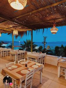 a restaurant with tables and chairs and a view of the ocean at Ekin Assos in Ayvacık