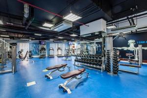 a gym with a blue floor and lots of machines at Spacious & classic Apartment in center of JBR in Dubai
