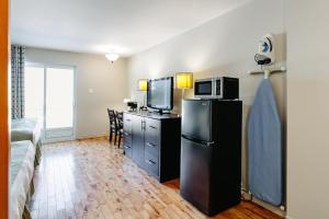 a hotel room with a refrigerator and a microwave at Mon Joli Motel in Sainte-Flavie