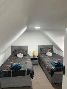 a attic bedroom with two beds in a attic at Mortlach Cottage in Dufftown