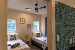 a bedroom with two beds and a glass wall at Aitutaki Holiday Villa in Arutanga
