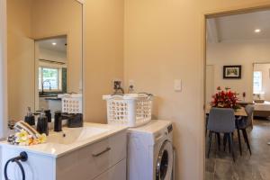 a bathroom with a sink and a washing machine at Aitutaki Holiday Villa in Arutanga