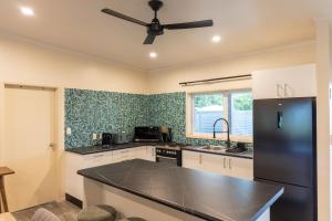 a kitchen with a ceiling fan and a black refrigerator at Aitutaki Holiday Villa in Arutanga +3 photos
