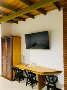 a dining room table with chairs and a flat screen tv on the wall at BUENAVISTA INN in Maiquetía
