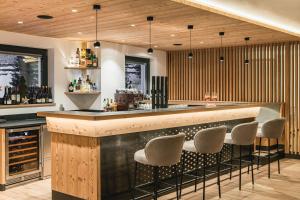 un bar con sgabelli in una stanza con legno di Hotel Wolf a Selva di Val Gardena