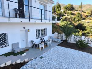 a white house with a balcony with a table and chairs at Planta independiente en Villa Primavera in Mijas