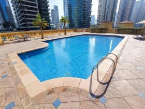 a swimming pool in a city with tall buildings at Spacious & classic Apartment in center of JBR in Dubai +36 photos