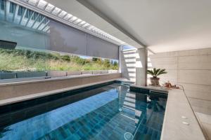a swimming pool with a view of a house at Luxury Private Spa Apartment with Heated Pool & Sauna and Sea View in Cavtat