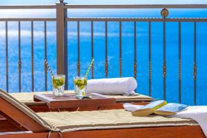 a table with two glasses of wine on a balcony at Apartments Mrkan 2 in Cavtat
