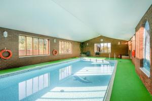 a large swimming pool in a house with green floors at 2 Bed in Smallburgh oc-h33734 in Dilham