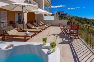 a patio with chairs and an umbrella on a building at Apartments Mrkan 2 in Cavtat