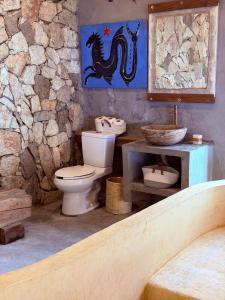 Ein Steinbadezimmer mit Toilette und Waschbecken in der Unterkunft Casa Guií in Arroyo Cruz