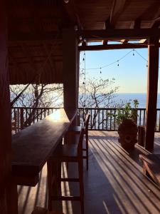 Ein Holztisch und Stühle auf einer Veranda mit Blick auf das Meer in der Unterkunft Casa Guií in Arroyo Cruz