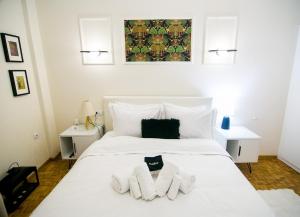 a bedroom with a white bed with towels on it at Twins in Serres