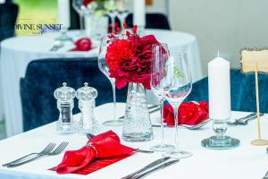 a white table with red flowers and wine glasses at Olifile Boutique Hotel & Restaurant in Midrand +55 photos