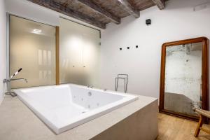 a large white bath tub in a room at Osterio Magno in Cefalù