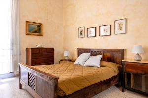 a bedroom with a bed and a dresser and pictures on the wall at Osterio Magno in Cefalù