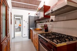 a large kitchen with a stove top oven at Osterio Magno in Cefalù