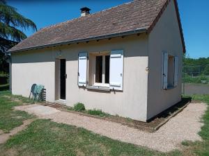 a small white house with two windows and a chair at Chez Wan'Elle in Thorigné-sur-Dué