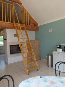 a wooden staircase in a room with a fireplace at Chez Wan'Elle in Thorigné-sur-Dué