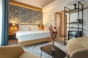 a bedroom with a bed and a vase of flowers on a table at Hotel Bronzo Brno in Brno