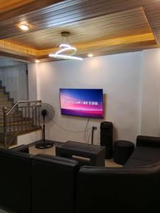 a room with a flat screen tv on a wall at Caperina del Casa-Rental in Naic