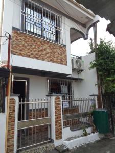 a house with a gate and a fence at Caperina del Casa-Rental in Naic