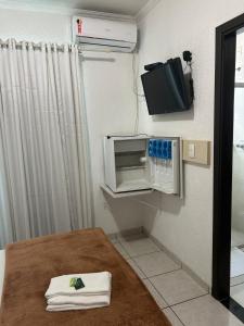a room with a microwave and a table with towels at Argentin Palace Hotel in Americana