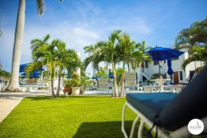 a lawn with palm trees and a table with an umbrella at Gulfside Resort Unit 2 in St. Pete Beach