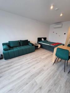 a living room with a green couch and a fireplace at Sea and lake KinKas in Mielno