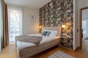 a bedroom with a bed with a floral accent wall at Pargi 21 Apartments in Tartu
