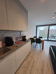 a kitchen with white cabinets and a table and chairs at Sea and lake KinKas in Mielno