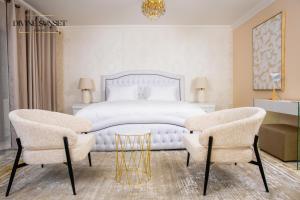 a bedroom with a white bed and two chairs at Olifile Boutique Hotel & Restaurant in Midrand