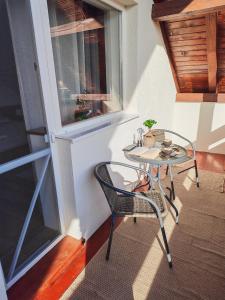 a balcony with a table and chairs and a window at Csergeteg Családi szállás in Ciceu +12 photos