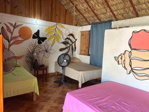 a room with two beds and a painting on the wall at Terra Tipi in Guayabas
