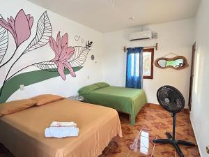 a bedroom with a bed and a flower mural on the wall at Terra Tipi in Guayabas +30 photos
