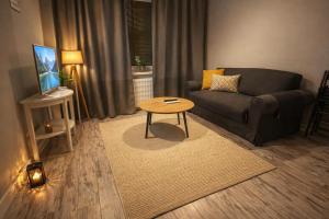 a living room with a couch and a table at Zlatá Víla by Cañas Apartments V srdci mesta, len pár krokov od hlavného námestia in Rimavská Sobota