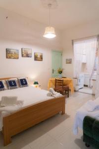 a bedroom with a large bed and a table at Stella Maris Marzamemi Apartments in Marzamemi