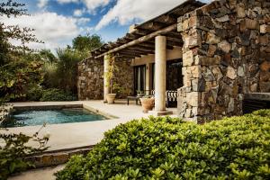 a stone house with a swimming pool and a patio at Awasi Mendoza in Ciudad Lujan de Cuyo