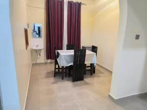 a dining room with a table and a red curtain at Ark House in Soroti