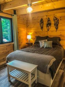 a bedroom with a bed with a wooden wall at Chalet cozy en bord de lac in Saguenay +14 photos