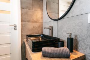 a bathroom with a black sink and a mirror at Derylovka - domki, jacuzzi, sauna in Zamość +64 photos