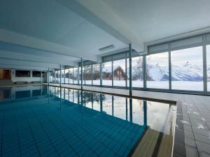 a swimming pool with a view of snow covered mountains at Nendaz Alpine Studio - Ski & Swimming Pool in Nendaz