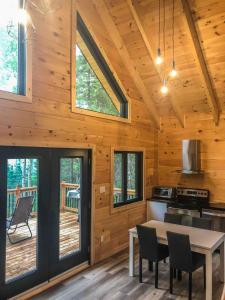a kitchen and dining room of a log cabin at Chalet cozy en bord de lac in Saguenay