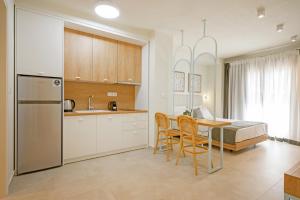 a kitchen and dining room with a table and a bed at Leon Apartments in Ierissos