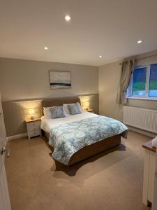 a bedroom with a large bed and two night stands at Lake View Lodge in Saint Columb Major +21 photos