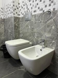 a bathroom with a white sink and a toilet at Bejart Apartment 8 in Tirana
