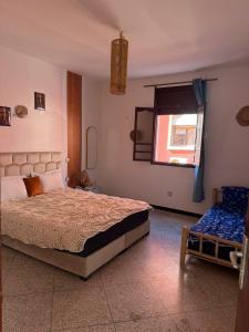 a bedroom with a large bed and a window at Dar Laila Surf in Tamraght Ouzdar